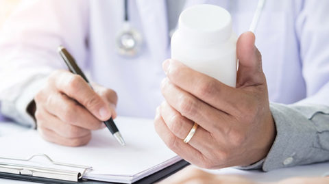 Chiropractor looking at paperwork and bottle